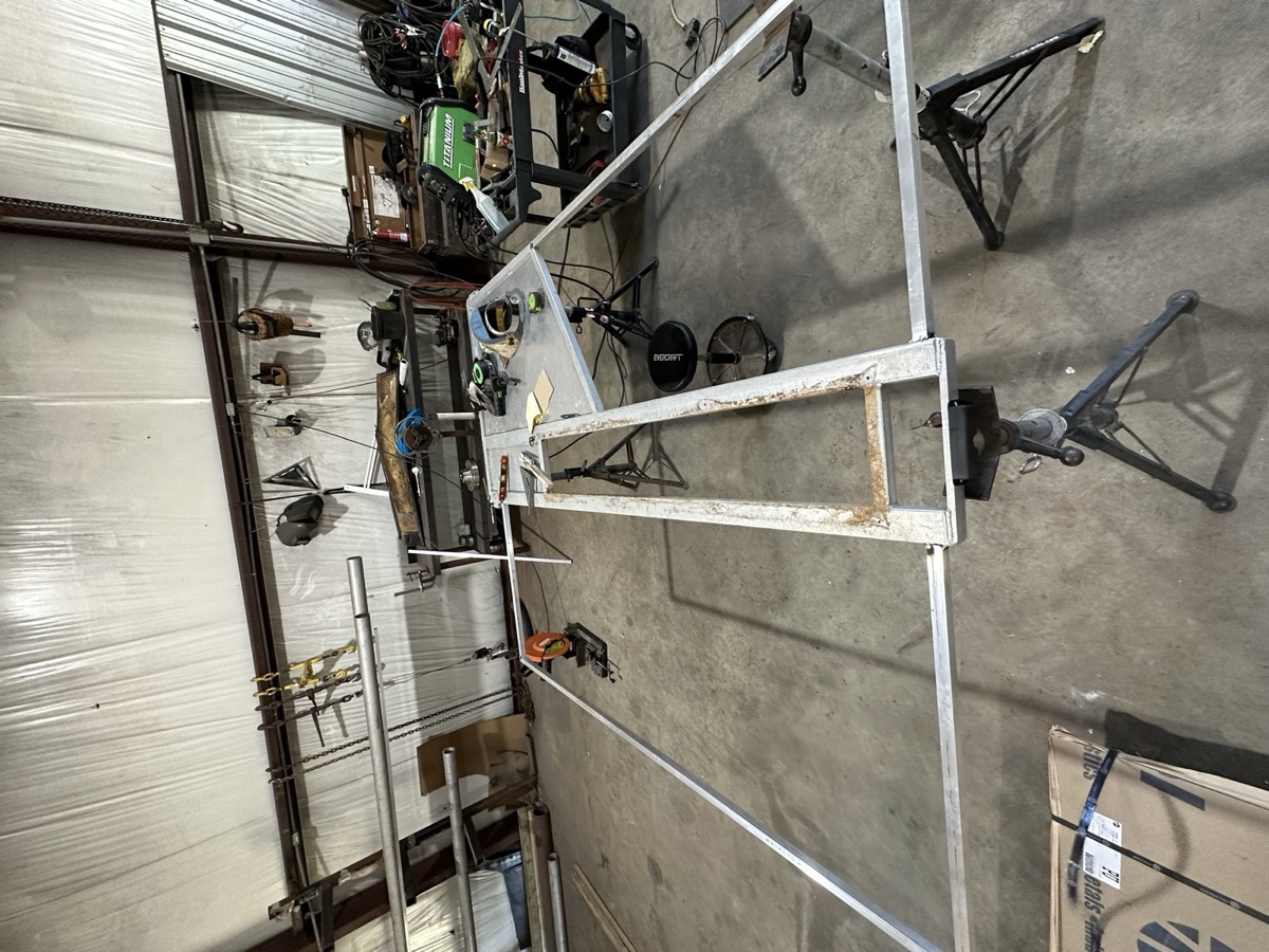 Large aluminum frame being laid out on jack stands for fabrication in the shop
