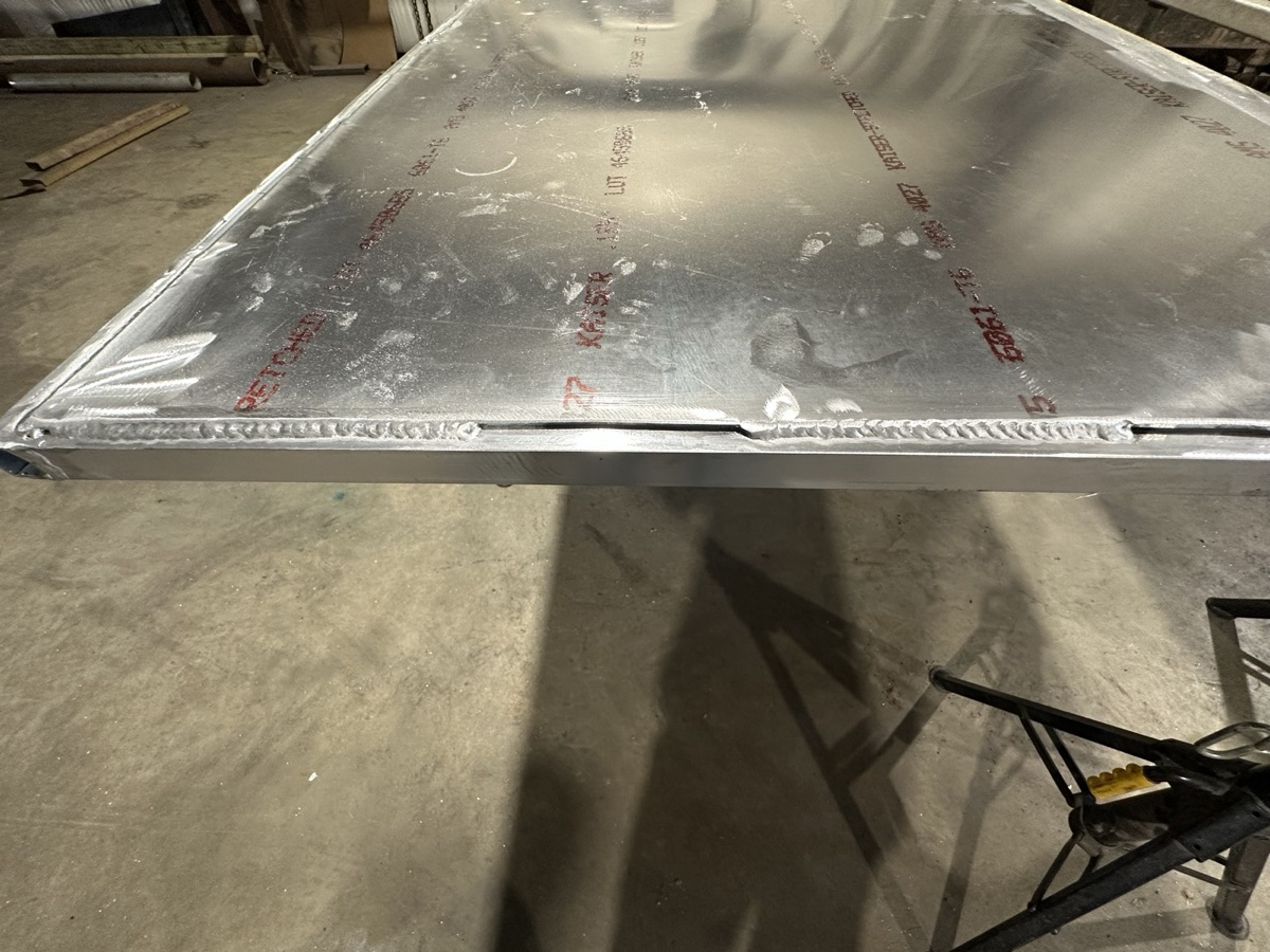 Welded aluminum sheet panel on jack stands in the shop