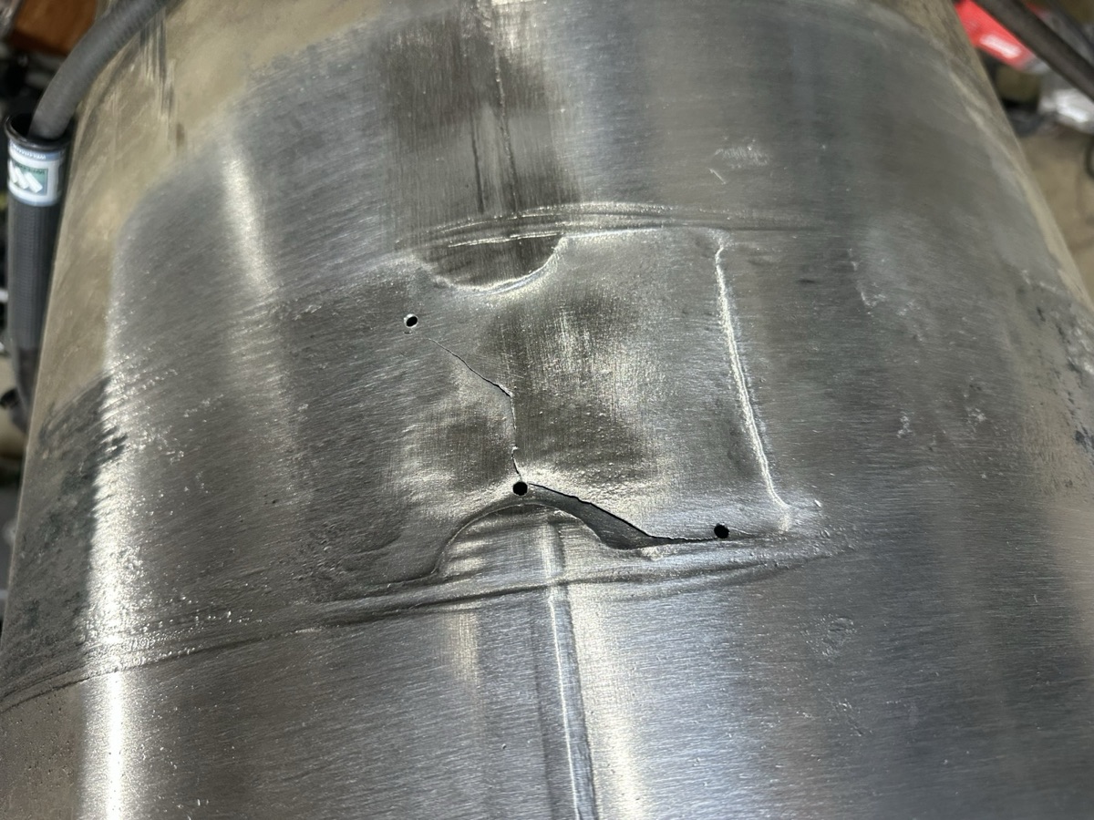 Aluminum tank with crack and pinholes visible before weld repair