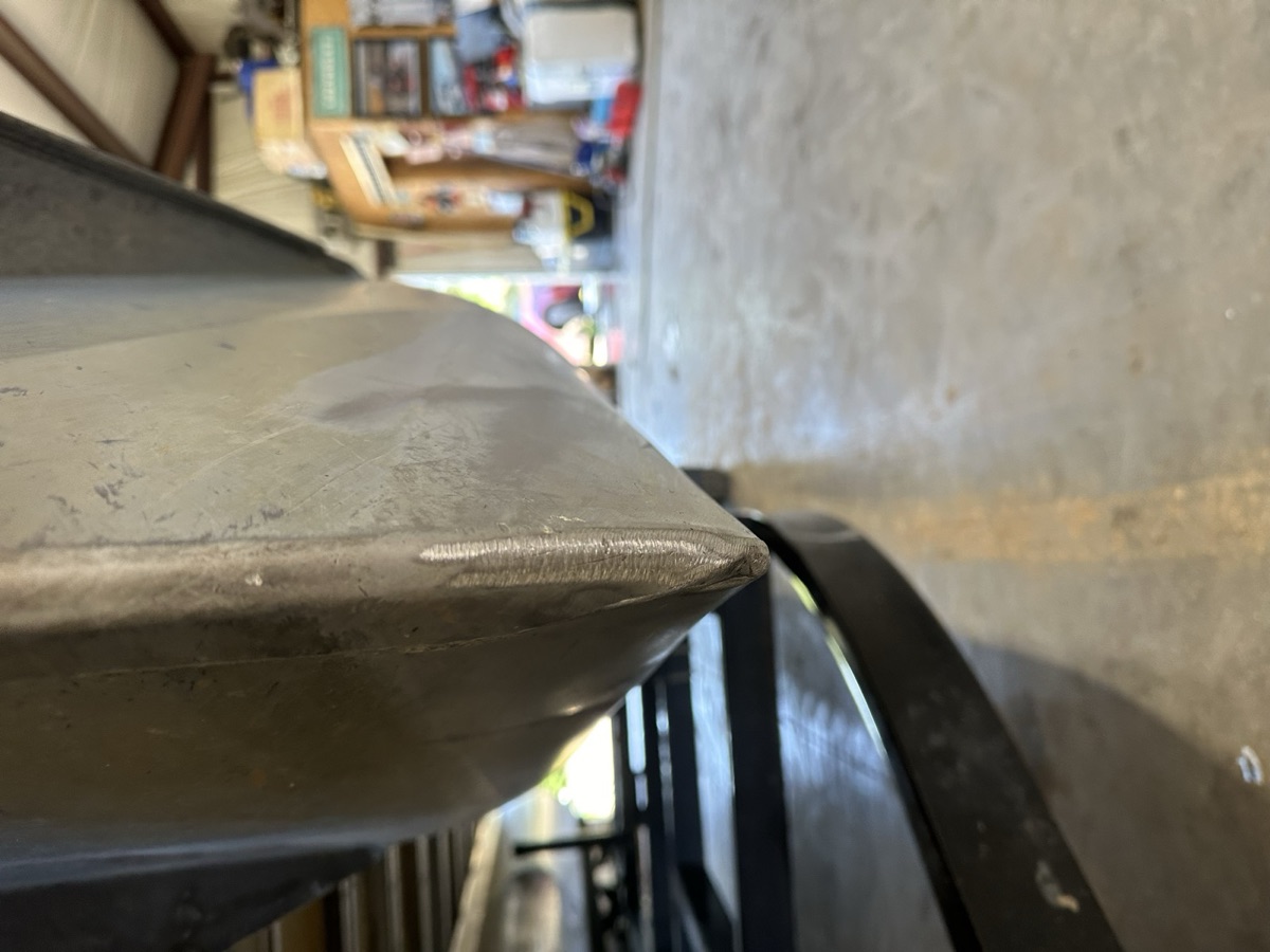 Aluminum weld bead on a boat hull inside a shop