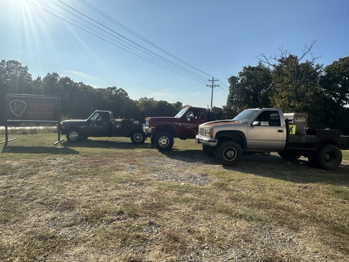 Iron Wolfe Welding shop building and sign with two welding trucks parked outside