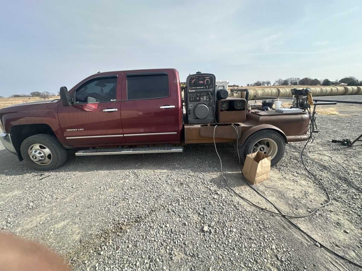 Mobile welding truck set up at a field pipe welding job with large pipe on stands