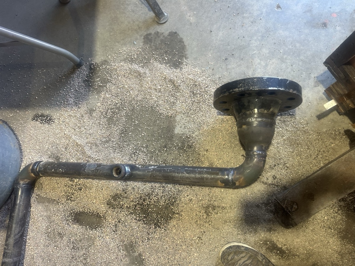 Steel pipe with welded flange sitting on a shop floor