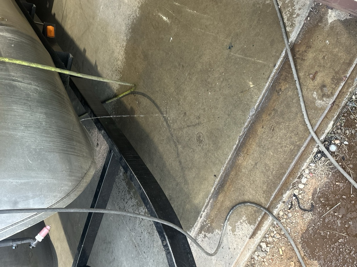 Large metal tank on a trailer leaking water before repair